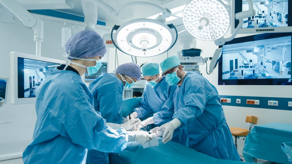 A group of surgeons operating on a patient in an operating room.