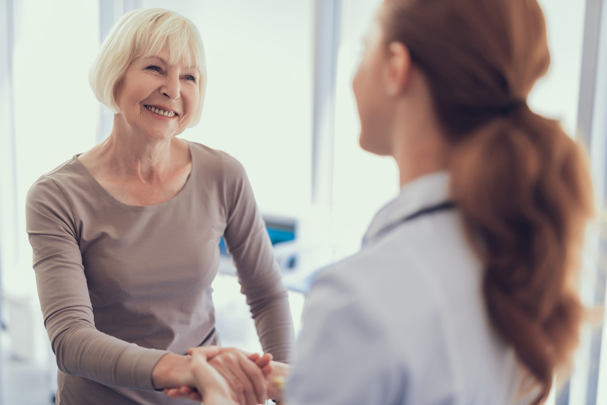 happy aged woman is thanking doctor for care