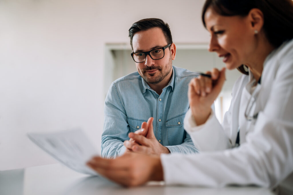 close up image of smiling man listening to a female healthcare w