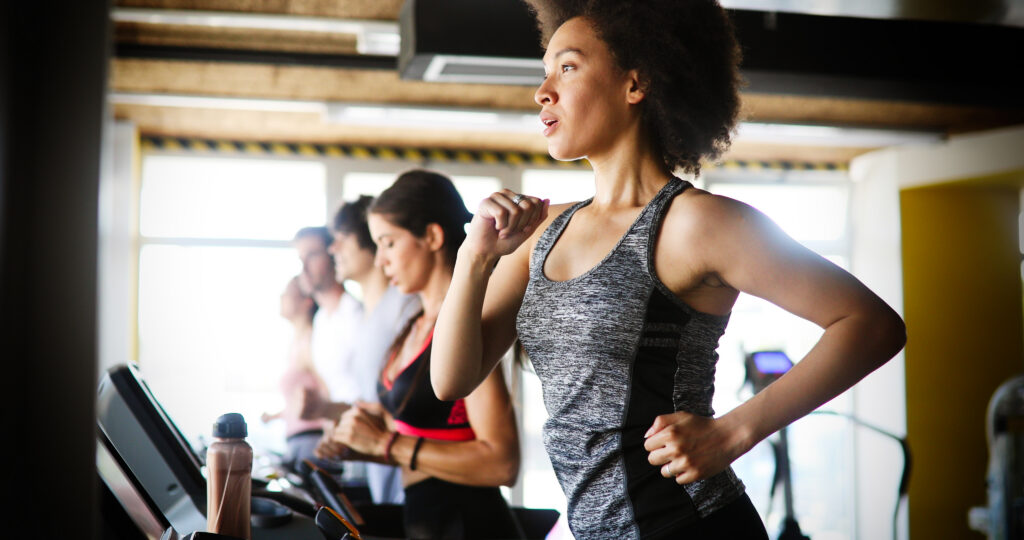 group of fit healthy friends people cardio workout in gym