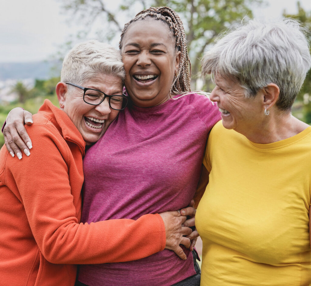 happy multiracial senior women having fun together at park eld